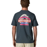 Man wearing Patagonia men's great waves responsibili short sleeve shirt in dark blue with large wave graphic on upper back