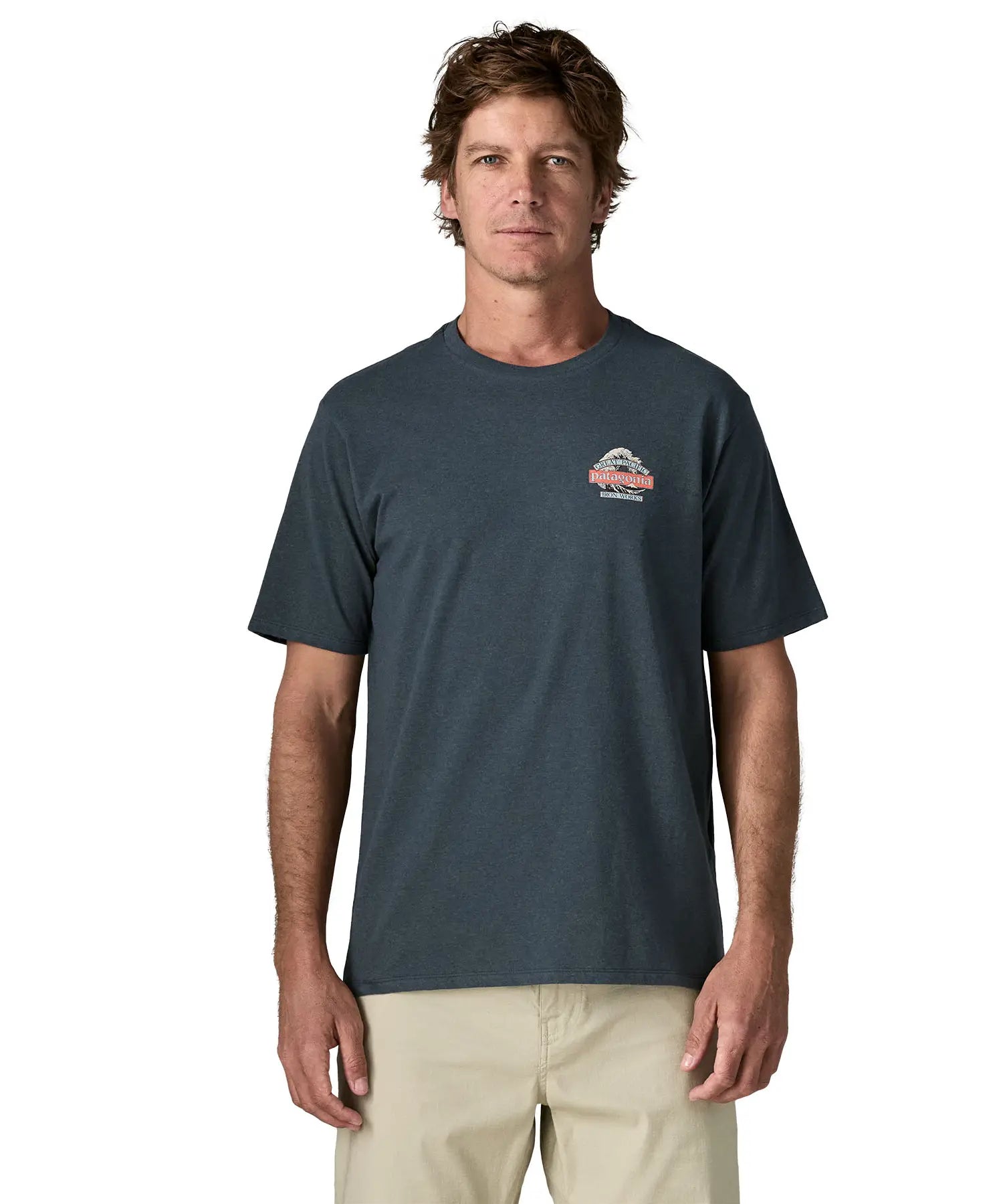 Man wearing Patagonia men's great waves responsibili short sleeve shirt in dark blue with small wave graphic on chest