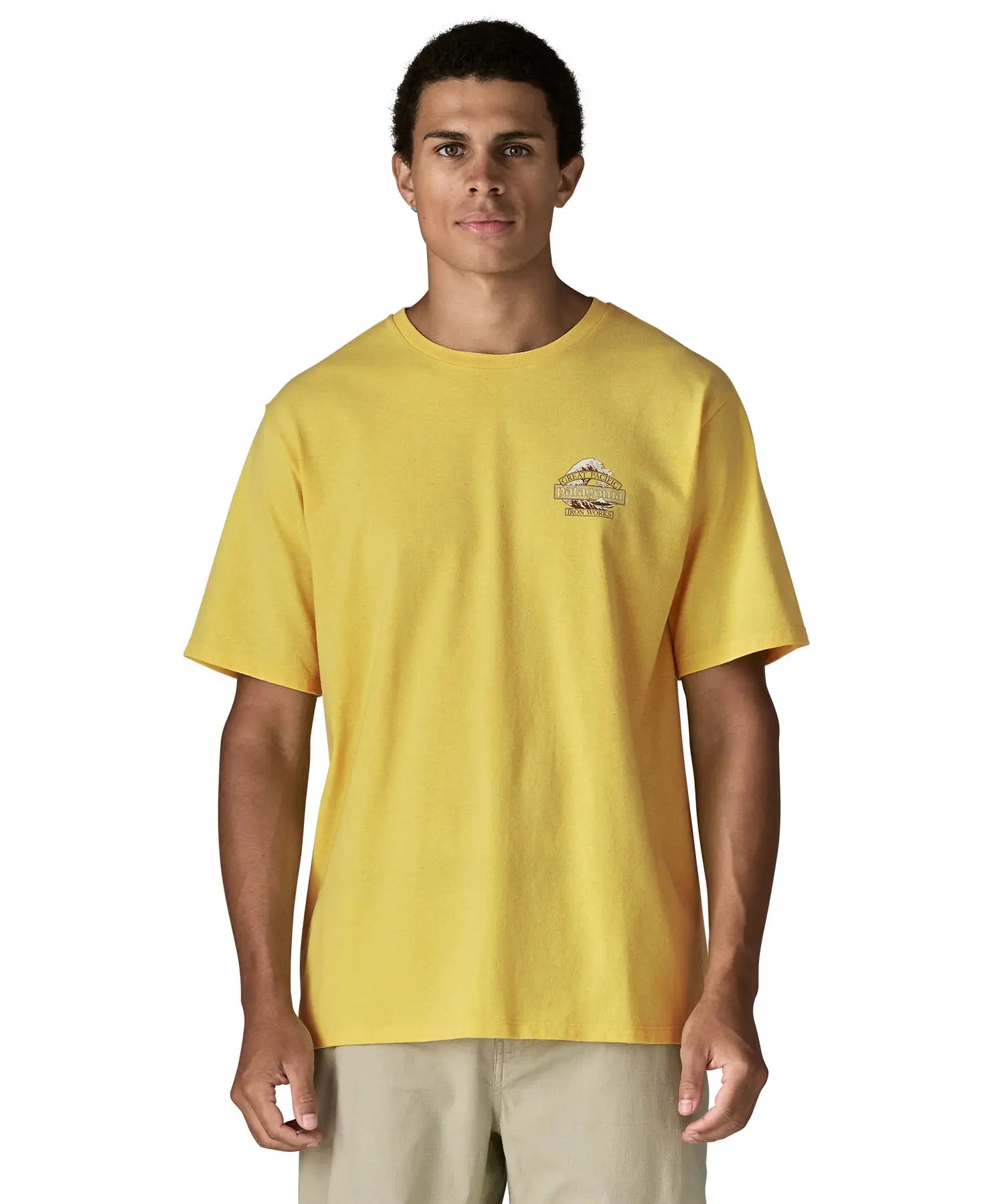 Man wearing Patagonia men's great waves responsibili short sleeve shirt in yellow with small wave graphic on chest
