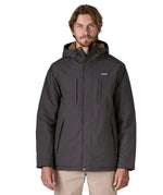 Man wearing Patagonia water repellent Isthmus parka in ink black showing full front zip and popper fastened and pockets