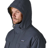 Patagonia's isthmus parka jacket in dark blue with the hood over the head showing toggles for tightness adjustment