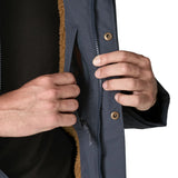 Man opening a inside pocket on the Patagonia's isthmus parka jacket in dark blue 