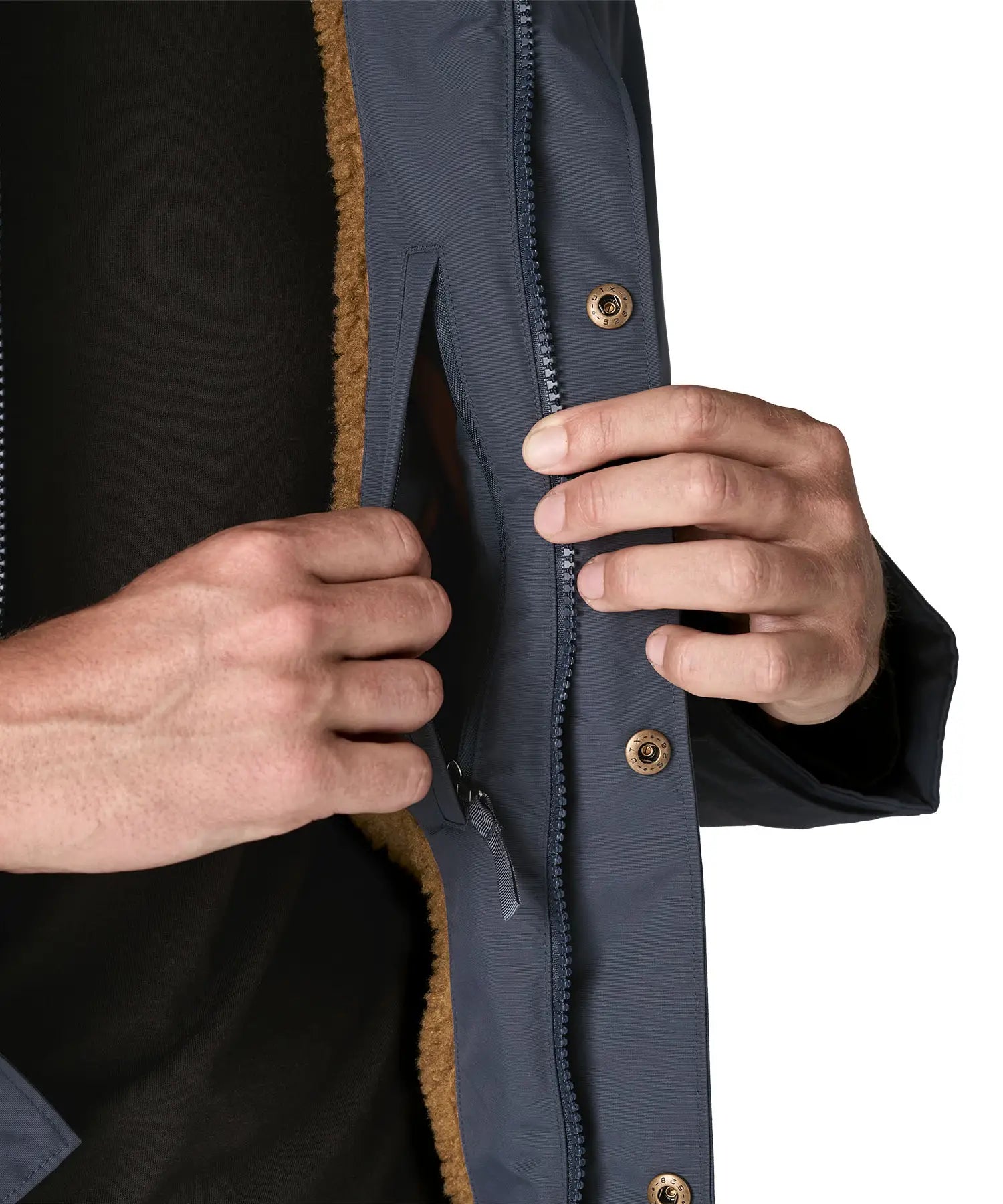 Man opening a inside pocket on the Patagonia's isthmus parka jacket in dark blue 