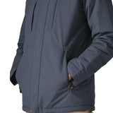 Man with hands in the side pockets on  Patagonia's isthmus parka jacket in dark blue 