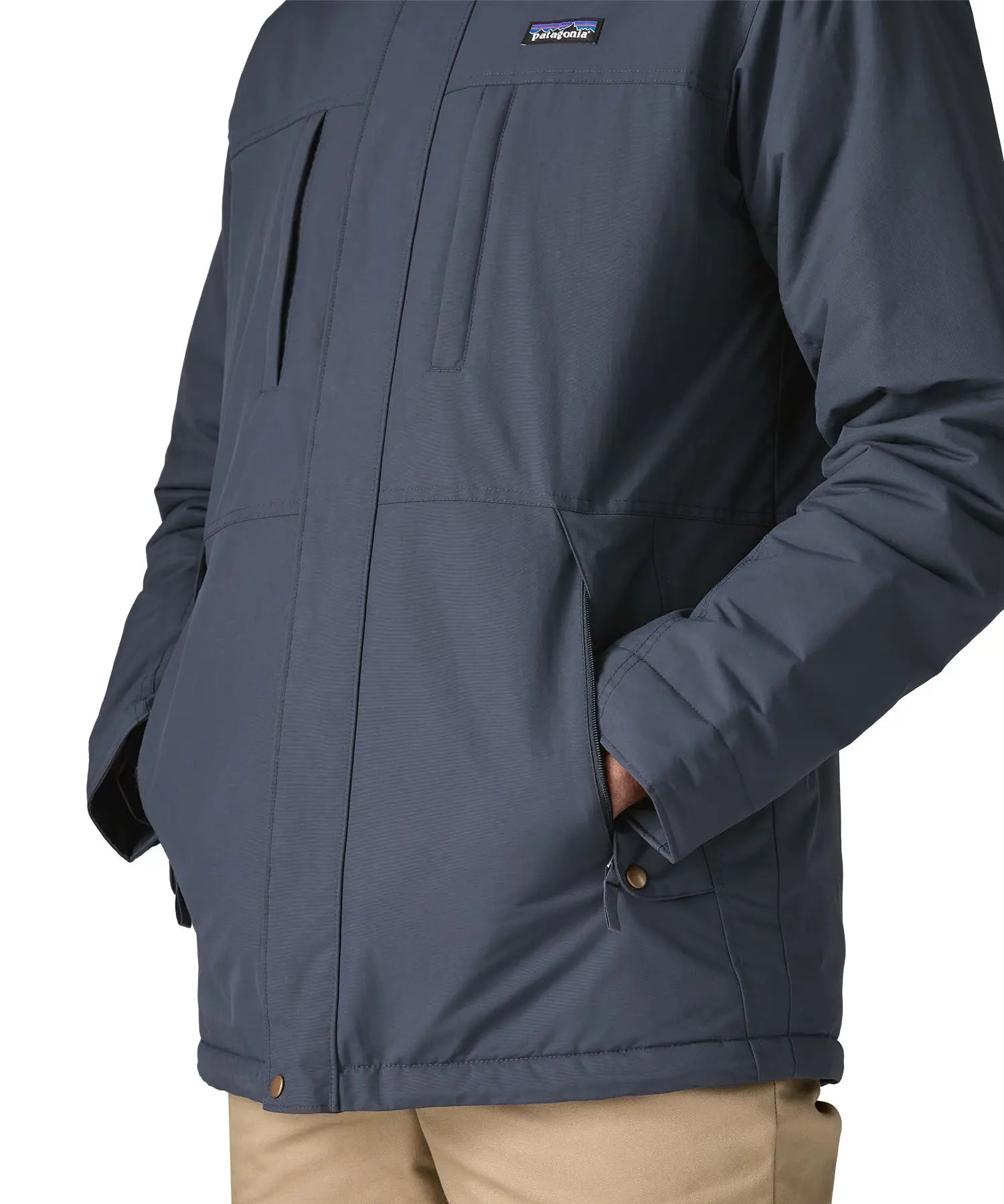 Man with hands in the side pockets on  Patagonia's isthmus parka jacket in dark blue 