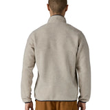 Back of Man wearing Patagonia's lightweight synchilla snap t fleece pullover in beige with navy trim. Jacket has a regular fit