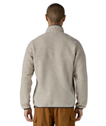 Back of Man wearing Patagonia's lightweight synchilla snap t fleece pullover in beige with navy trim. Jacket has a regular fit