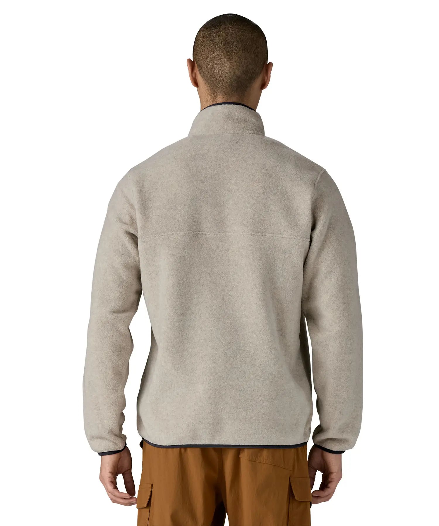 Back of Man wearing Patagonia's lightweight synchilla snap t fleece pullover in beige with navy trim. Jacket has a regular fit