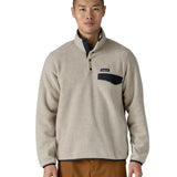 Man wearing Patagonia's lightweight synchilla snap t fleece pullover in beige with navy trim showing 1/4 length popper fasteners and chest pocket