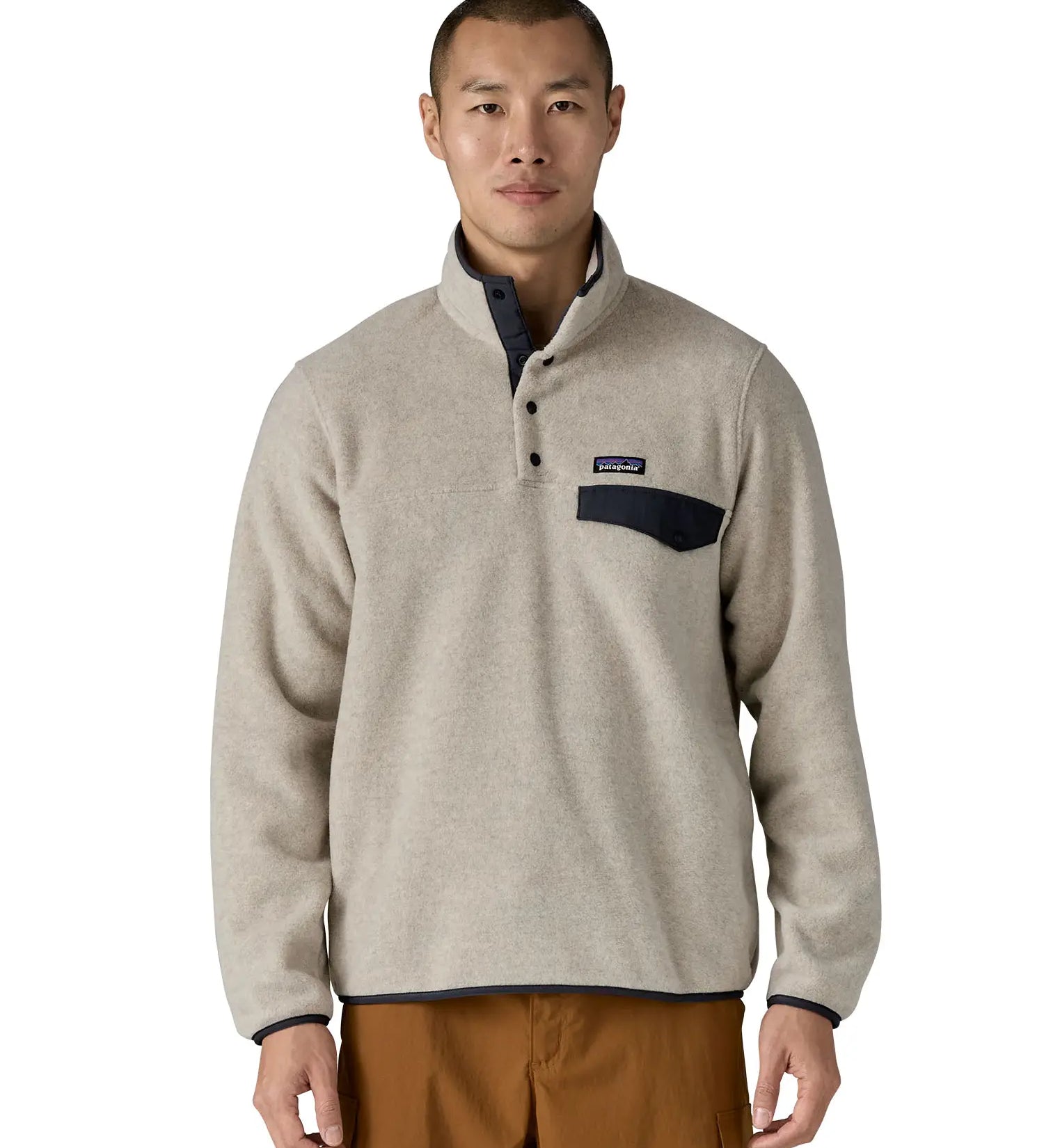Man wearing Patagonia's lightweight synchilla snap t fleece pullover in beige with navy trim showing 1/4 length popper fasteners and chest pocket