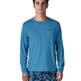 Man wearing Patagonia's men's long sleeve capilene cool t-shirt in light blue with small brand text on chest