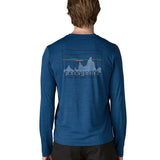 Man wearing Patagonia men's long sleeve capilene techincal t-shirt in blue showing 73 skyline inspired brand print on upper back 