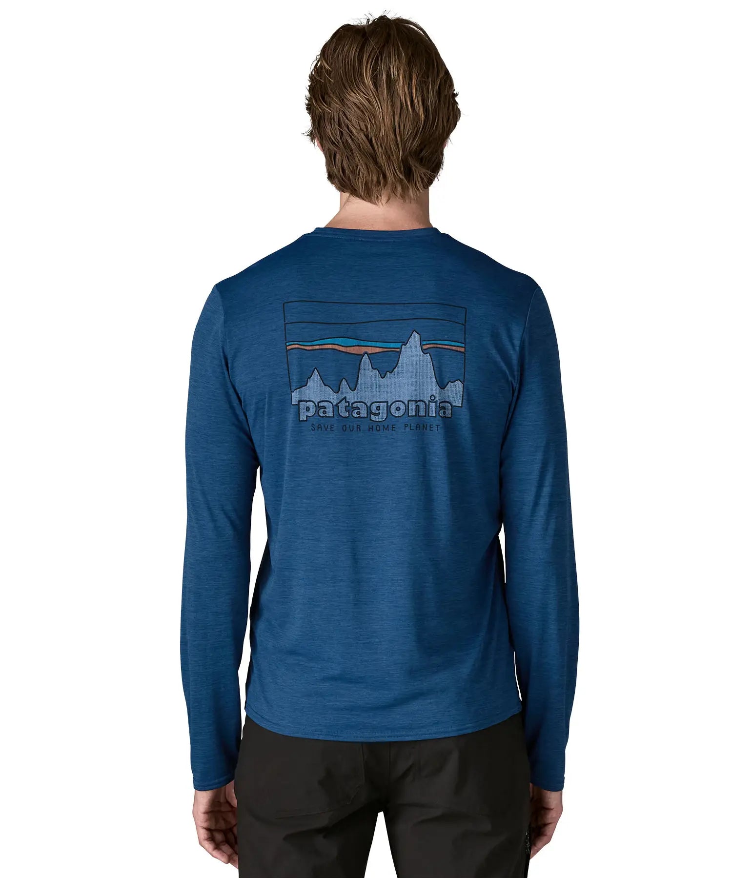 Man wearing Patagonia men's long sleeve capilene techincal t-shirt in blue showing 73 skyline inspired brand print on upper back 