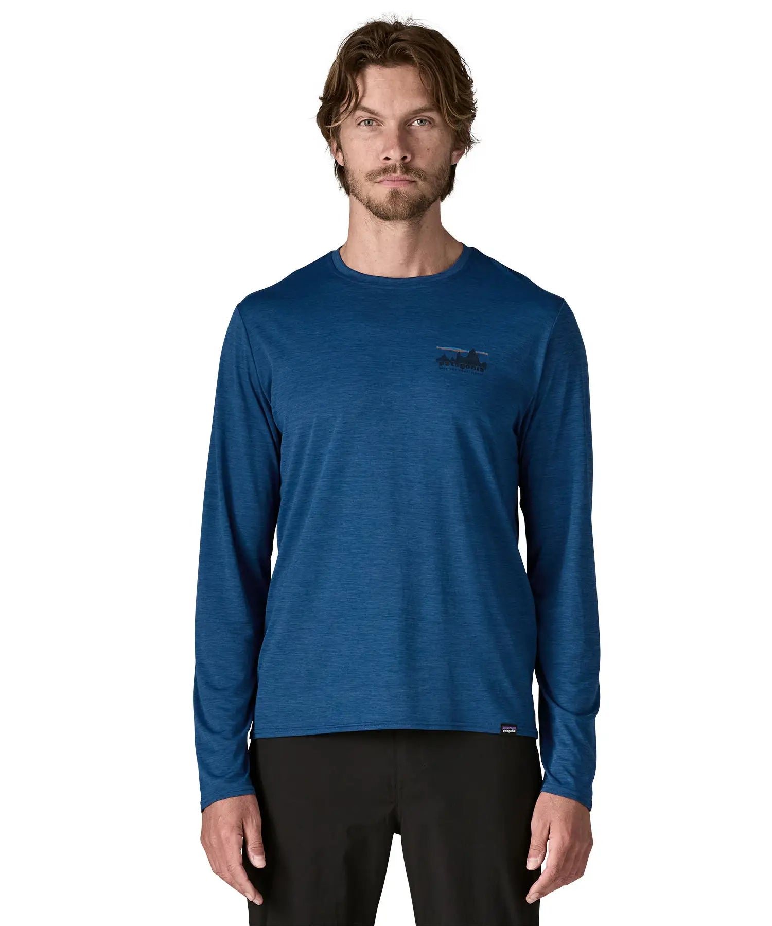 Man wearing Patagonia 73 skyline men's long sleeve capilene techincal t-shirt in blue. Top has a regular fit and sits around the hips