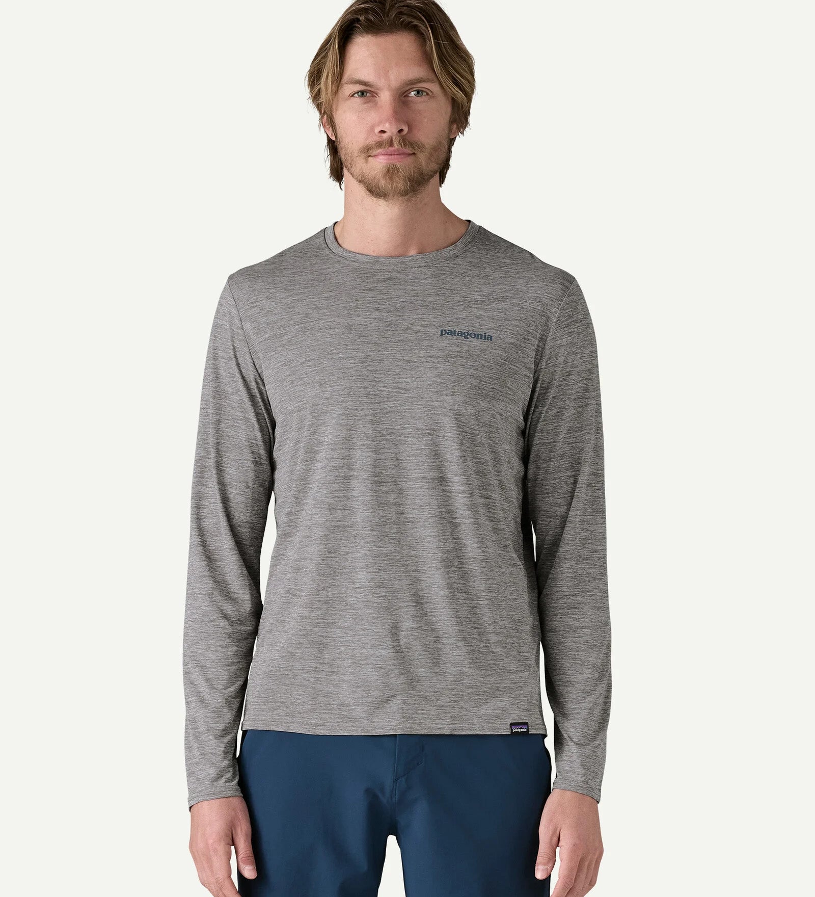 Front view of a man wearing the Patagonia Men’s Long Sleeved Capilene Cool Daily Graphic Shirt in Waters grey marl, with a small Patagonia logo on the left chest.