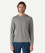 Front view of a man wearing the Patagonia Men’s Long Sleeved Capilene Cool Daily Graphic Shirt in Waters grey marl, with a small Patagonia logo on the left chest.