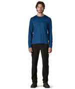 Man wearing Patagonia men's long sleeve capilene techincal t-shirt in 73 skyline clement blue. Top has a regular fit