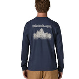 Man wearing Patagonia's long sleeve t-shirt in new navy showing a large white branded mountain range graphic on the upper back