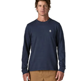 Man wearing Patagonia's hut tripper skyline long sleeve t-shirt in new navy showing a small P initial logo on the chest. Top has a relaxed fit