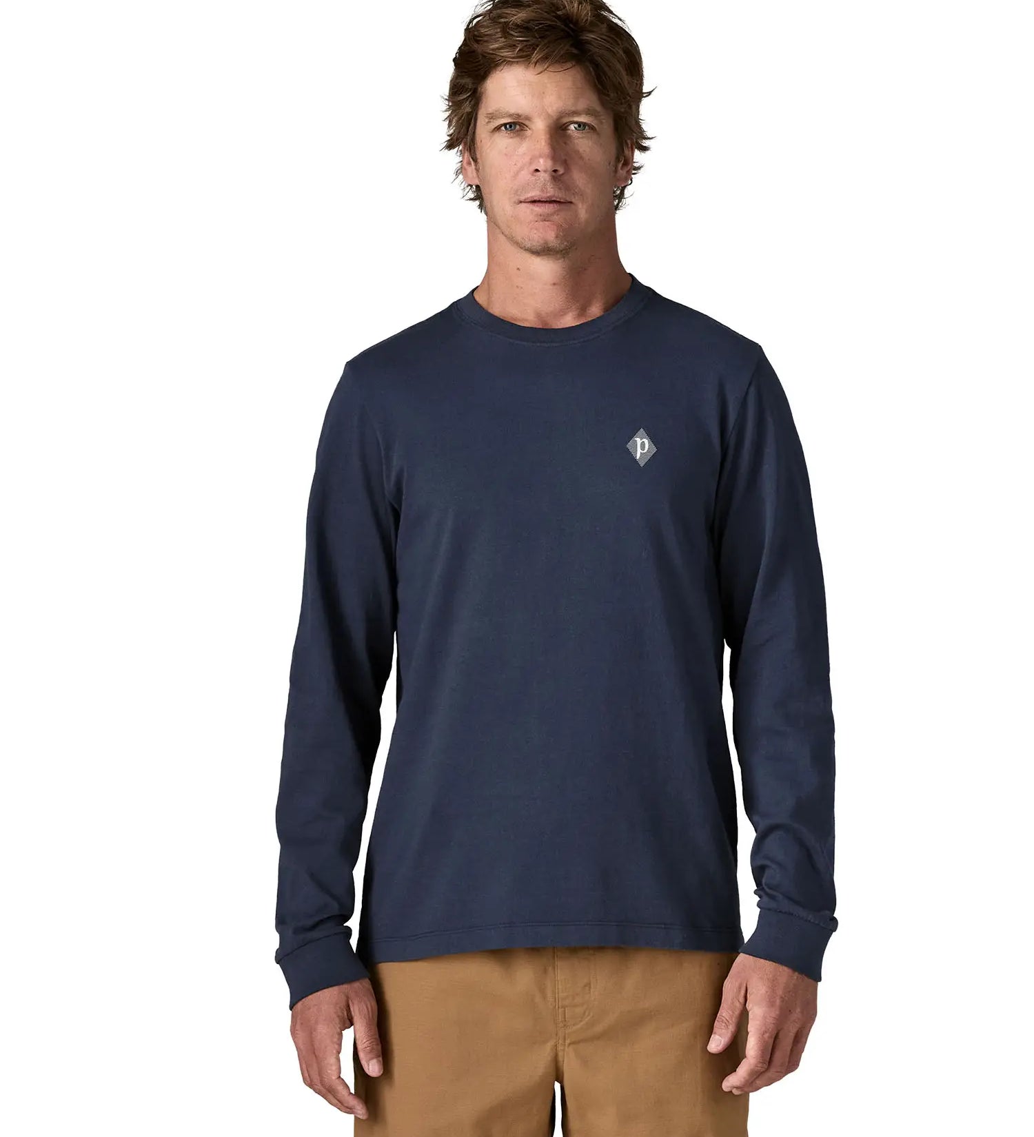 Man wearing Patagonia's hut tripper skyline long sleeve t-shirt in new navy showing a small P initial logo on the chest. Top has a relaxed fit