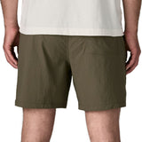 Back of man wearing Patagonia's men's outdoor everyday shorts in green. Shorts have a loose fit and sit above the knees