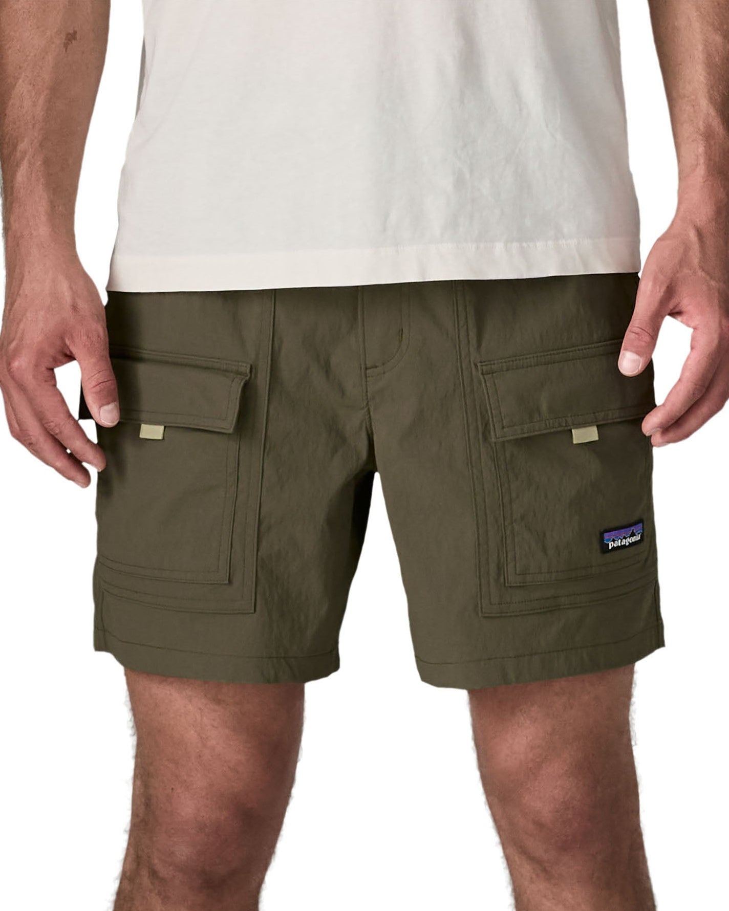 Man wearing Patagonia's men's outdoor everyday shorts in green. Shows front pockets. Shorts have a loose fit