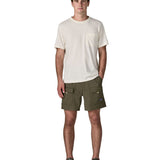 Man wearing Patagonia's men's outdoor everyday shorts in green. Shows front pockets. Shorts have a loose fit and sit over the knees