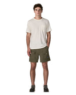 Man wearing Patagonia's men's outdoor everyday shorts in green. Shows front pockets. Shorts have a loose fit and sit over the knees