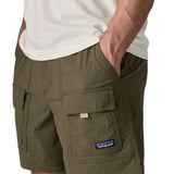 Man wearing Patagonia's men's outdoor everyday shorts in green. With hand in side pocket. Shorts have a loose fit