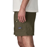 Side of man wearing Patagonia's men's outdoor everyday shorts in green. Shows front panel pockets.