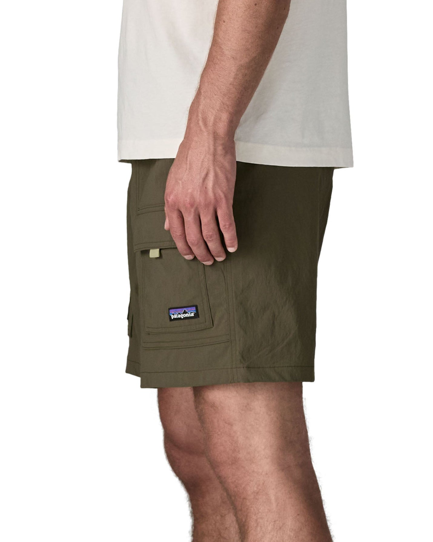 Side of man wearing Patagonia's men's outdoor everyday shorts in green. Shows front panel pockets.