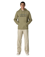 Man wearing Man wearing Patagonia's P-6 Logo Uprisal Hoody in a pale green with the hood down and hands in pouch pockets. Hoody has a relaxed fit