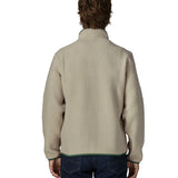 Back of man wearing a Patagonia retro pile jacket in beige with a green trim. Fleece has a relaxed fit