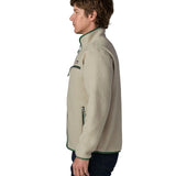 Side of man wearing a Patagonia retro pile jacket in beige with a green trim showing side and chest pockets and stand up collar