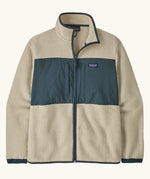 Patagonia men's retro pile patch jacket in beige with a navy trim and chest panel. Features chest pockets and elasticated cuffs