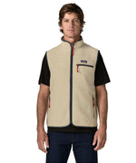 Man wearing Patagonia men's retro pile vest in beige with a navy trim. Showing front zip fastened. Gilet has a regular fit
