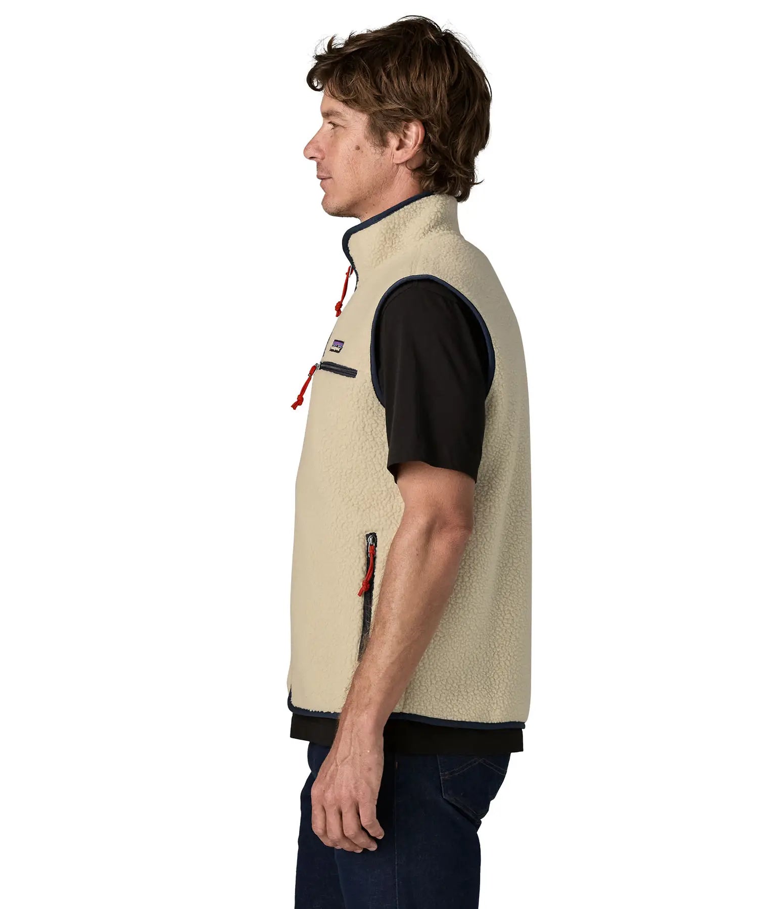 Side of man wearing Patagonia men's retro pile vest in beige with a navy trim. Gilet features a turned up collar
