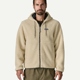 Front three quarter view of a man wearing the Patagonia Men’s Retro-X Fleece Hoody Jacket in Dark Natural, hands in the zippered pockets, showing the full zip and fleece texture.