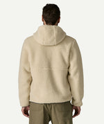 Back view of a man wearing the Patagonia Men’s Retro-X Fleece Hoody Jacket in Dark Natural, showing the hood and high pile fleece across the back.