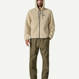 Full front view of a man wearing the Patagonia Men’s Retro-X Fleece Hoody Jacket in Dark Natural, showing the drawcord hood, full length zip and fleece texture.