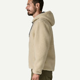Side profile of a man wearing the Patagonia Men’s Retro-X Fleece Hoody Jacket in Dark Natural with the hood down, showing the relaxed regular fit and high pile fleece.