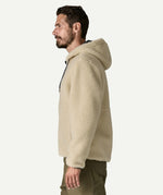 Side profile of a man wearing the Patagonia Men’s Retro-X Fleece Hoody Jacket in Dark Natural with the hood down, showing the relaxed regular fit and high pile fleece.