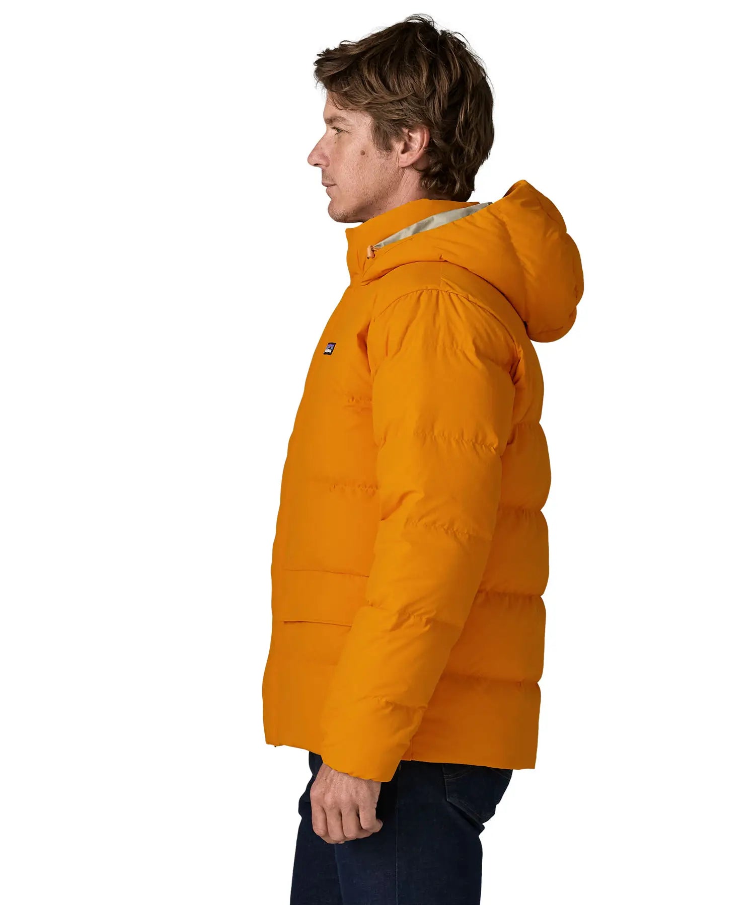 Side of man wearing Patagonia water repellent sisar thick down jacket in orange. Coat has a relaxed fir and sits at the hips