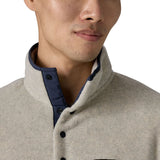 Close up of man wearing Patagonia's synchilla snap t fleece in light grey. Shows the 1/4 length front popper and high neck collar 