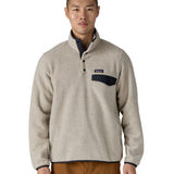 Man wearing Patagonia's recycled polyester synchilla snap t fleece in light grey. Fleece has a relaxed fit and sits at the waist.