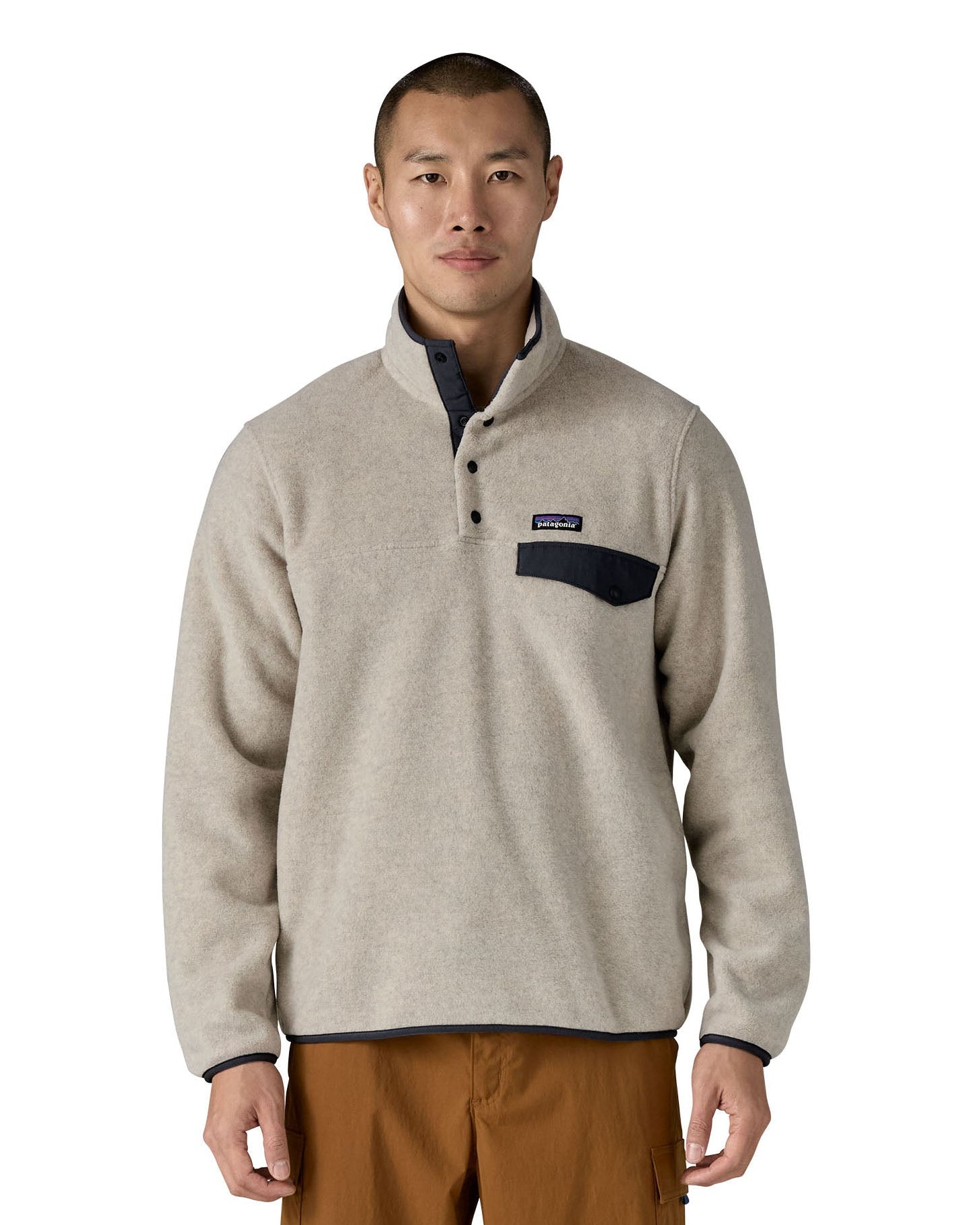 Man wearing Patagonia's recycled polyester synchilla snap t fleece in light grey. Fleece has a relaxed fit and sits at the waist.