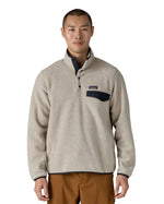 Man wearing Patagonia's recycled polyester synchilla snap t fleece in light grey. Fleece has a relaxed fit and sits at the waist.