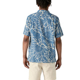 Back of man wearing Patagonia men's tidal  short sleeve shirt with light blue and cream Hawaiian inspired floral prints.