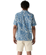 Back of man wearing Patagonia men's tidal  short sleeve shirt with light blue and cream Hawaiian inspired floral prints.