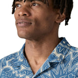 Man wearing Patagonia men's tidal threads short sleeve shirt with light blue and cream Hawaiia inspired prints showing collar detail
